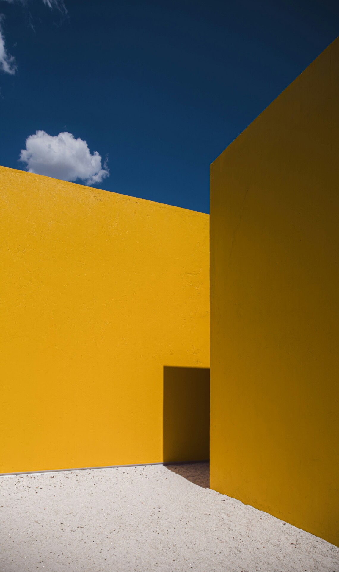 Yellow wall on sand with a blue sky