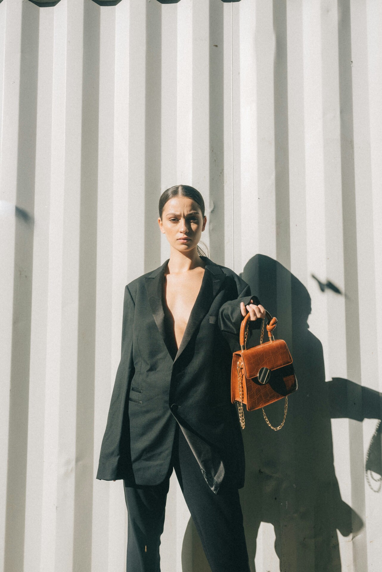 Ragazza con completo nero e borsa in pelle arancione