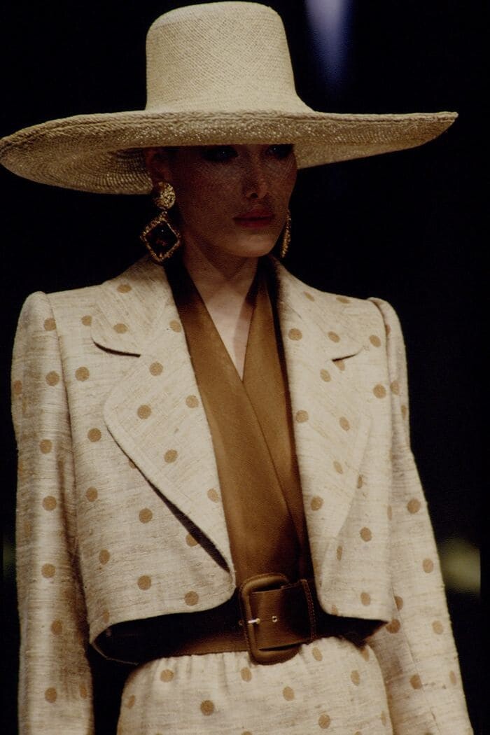 Vintage model in natural linen suit, raffia hat and gold earrings